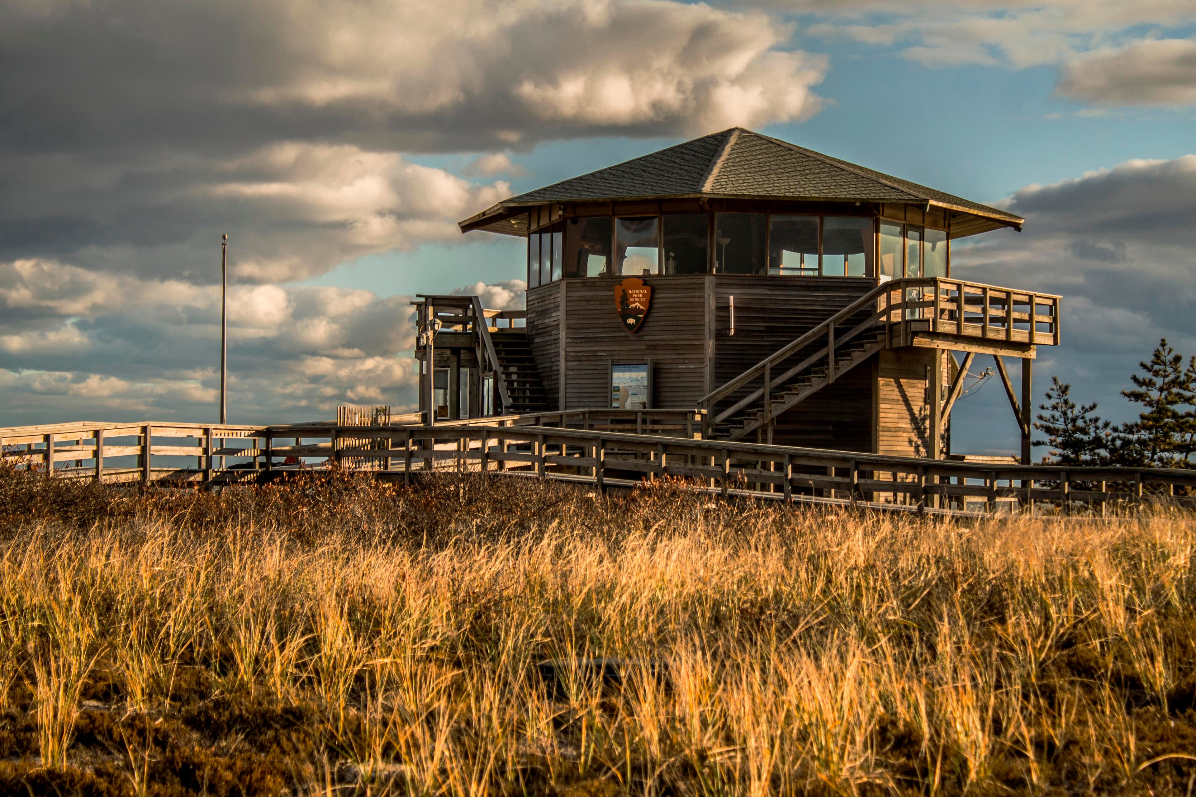 A brown hexagonally shaped building glows in the sunset light.