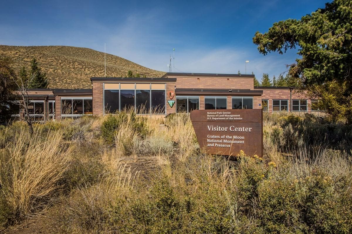A modern, boxy building surrounded by scrub. A sign out front reads, "Visitor Center."