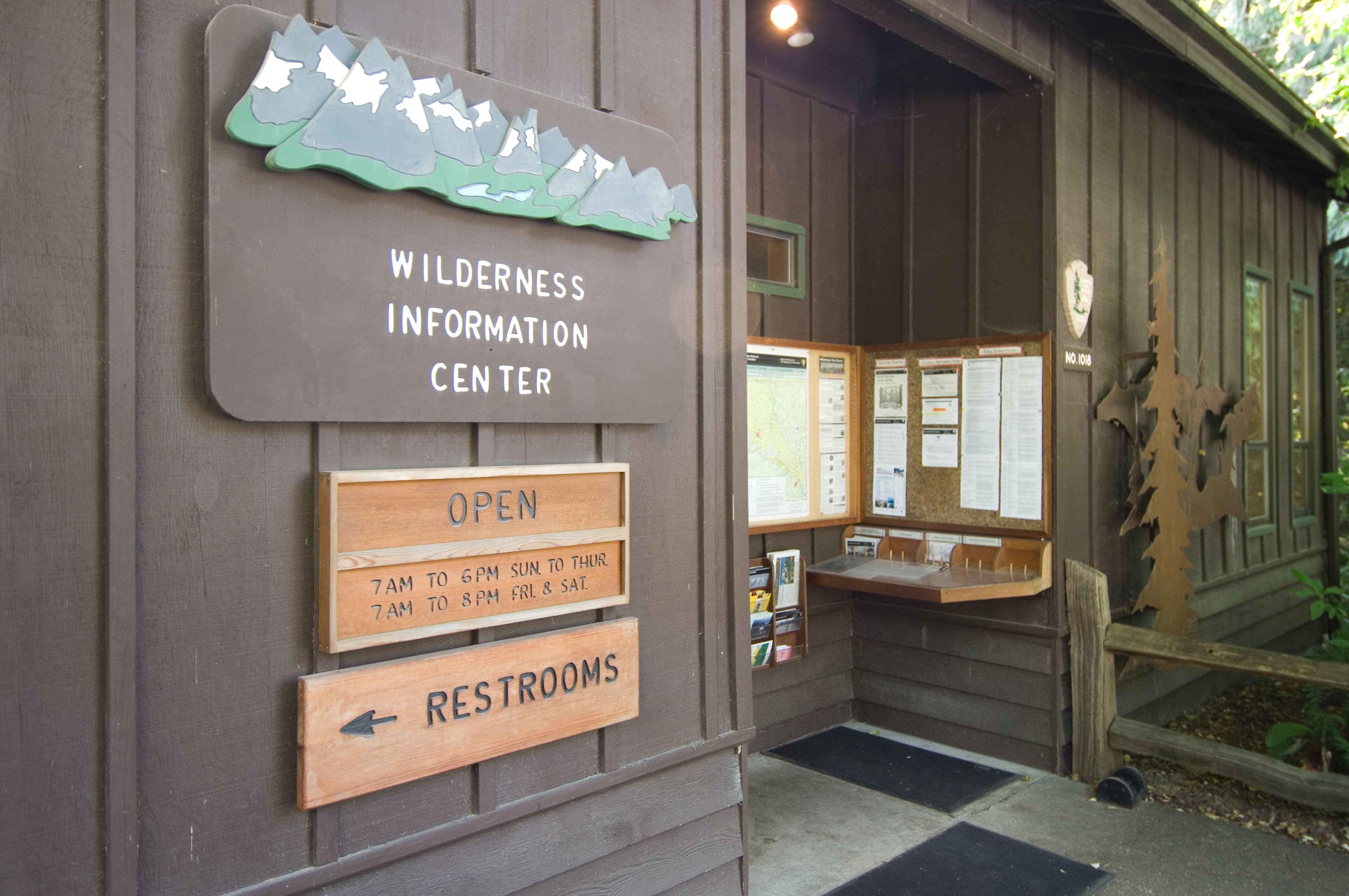 A brown cabin with bulletin boards out front