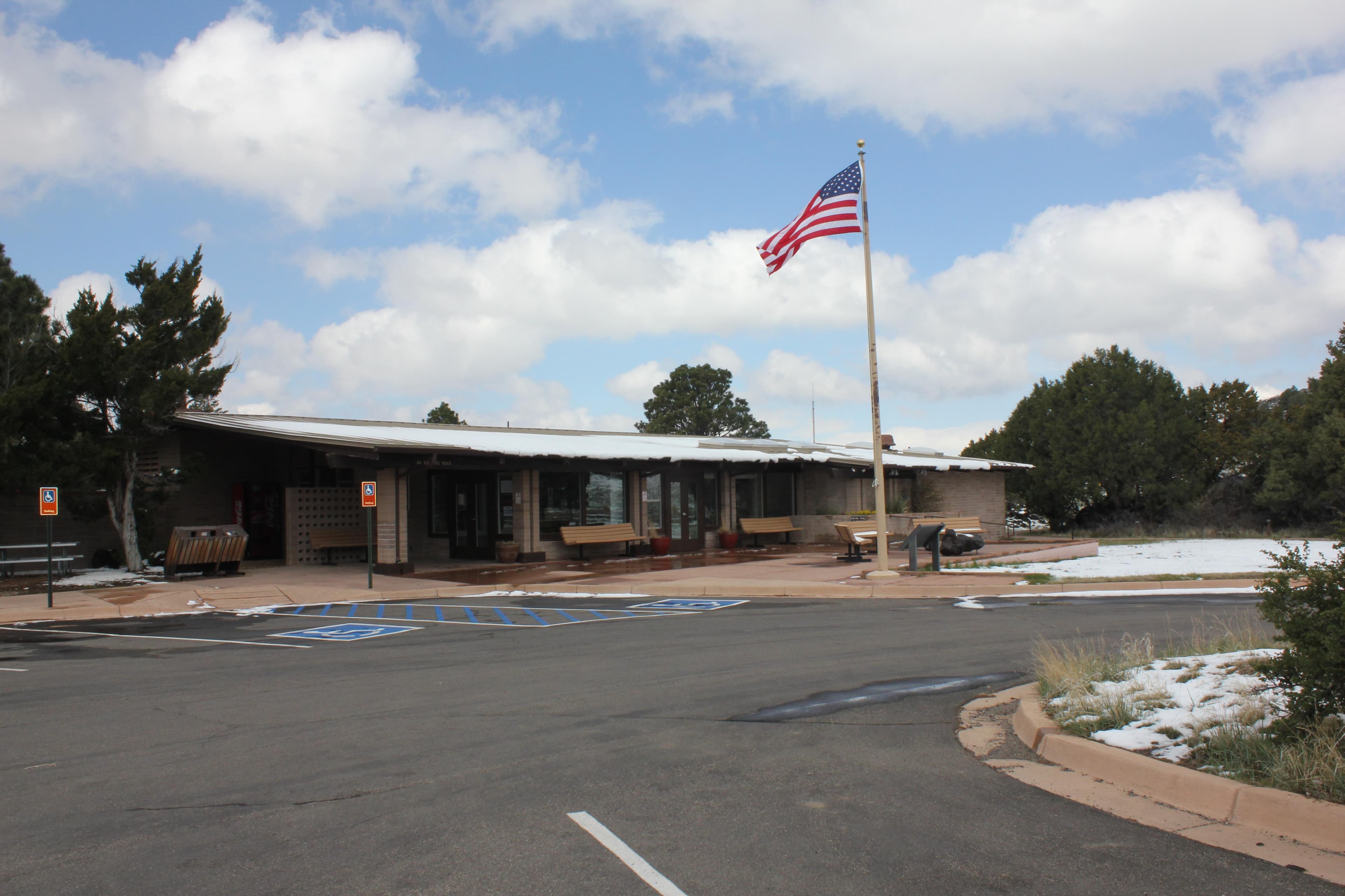 the visitor center building with the flag flying in front on a snowy day