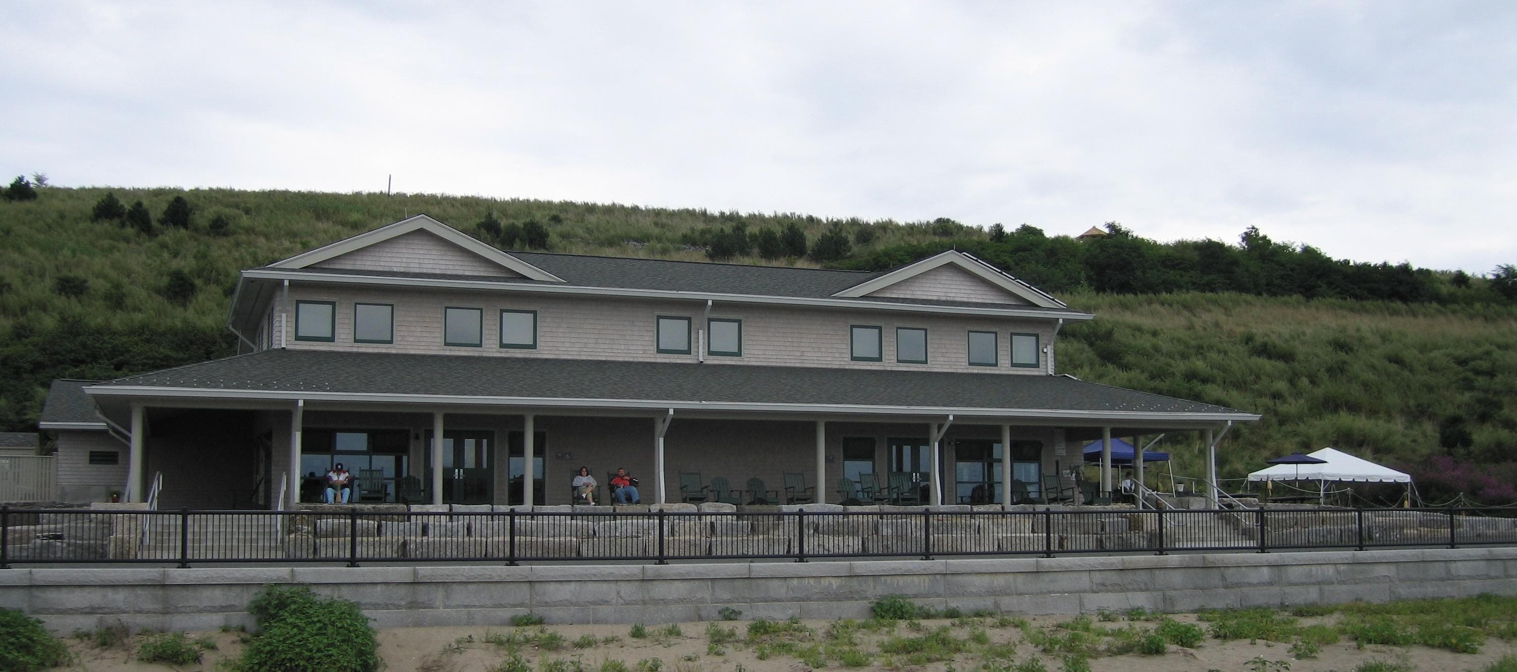 Three story building with a covered porch and a slanted roof.