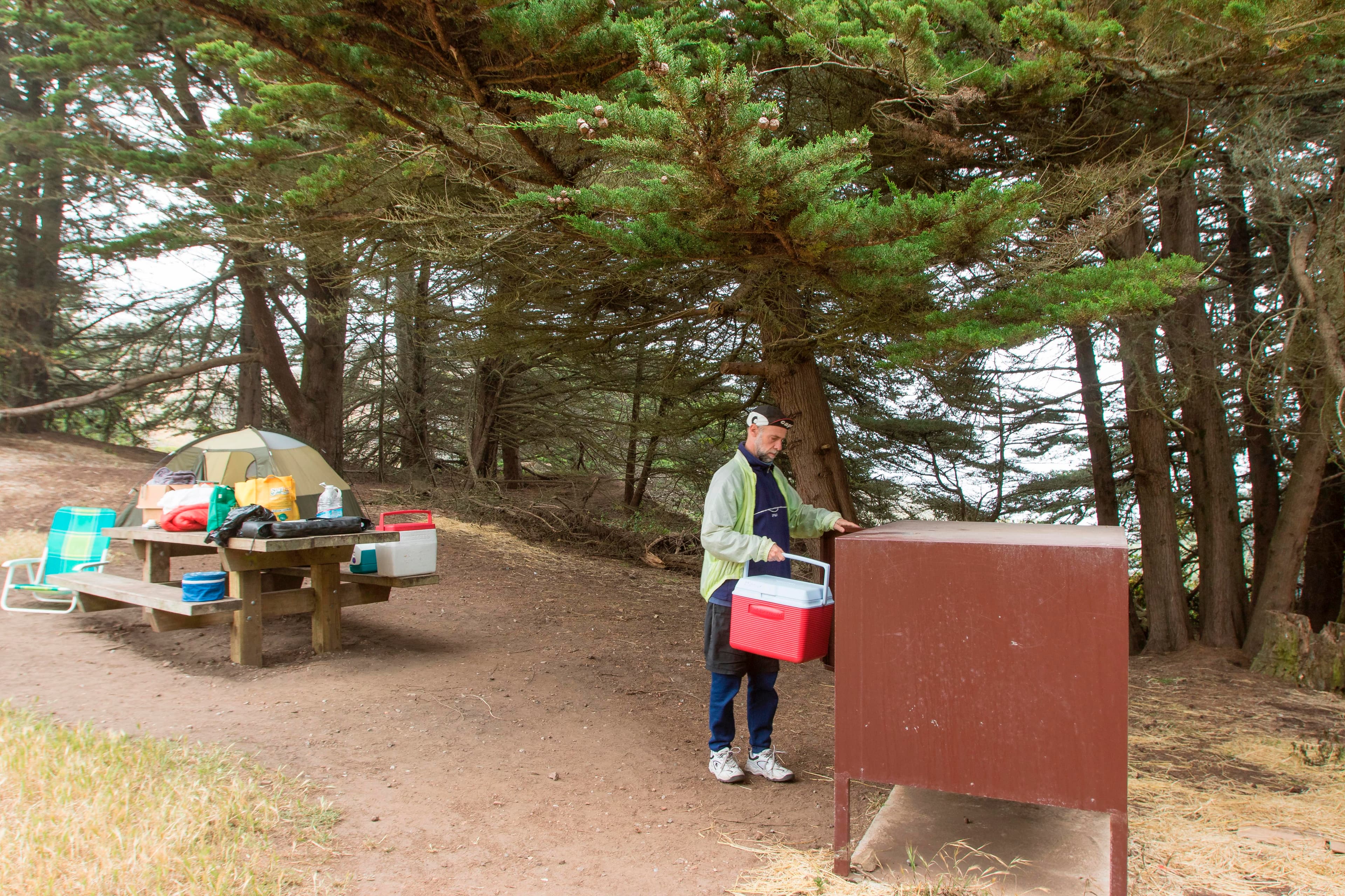 Campers make use of the food storage boxes and picnic tables at the campground.
