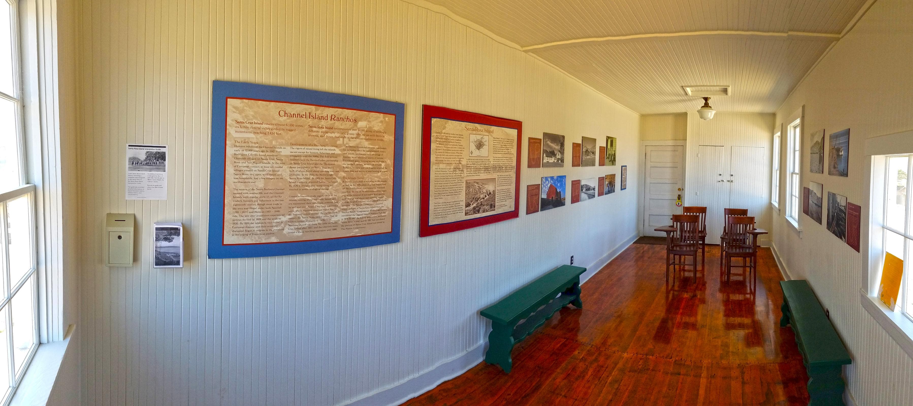 signs on walls, wood school desks and benches in small room with wood floor