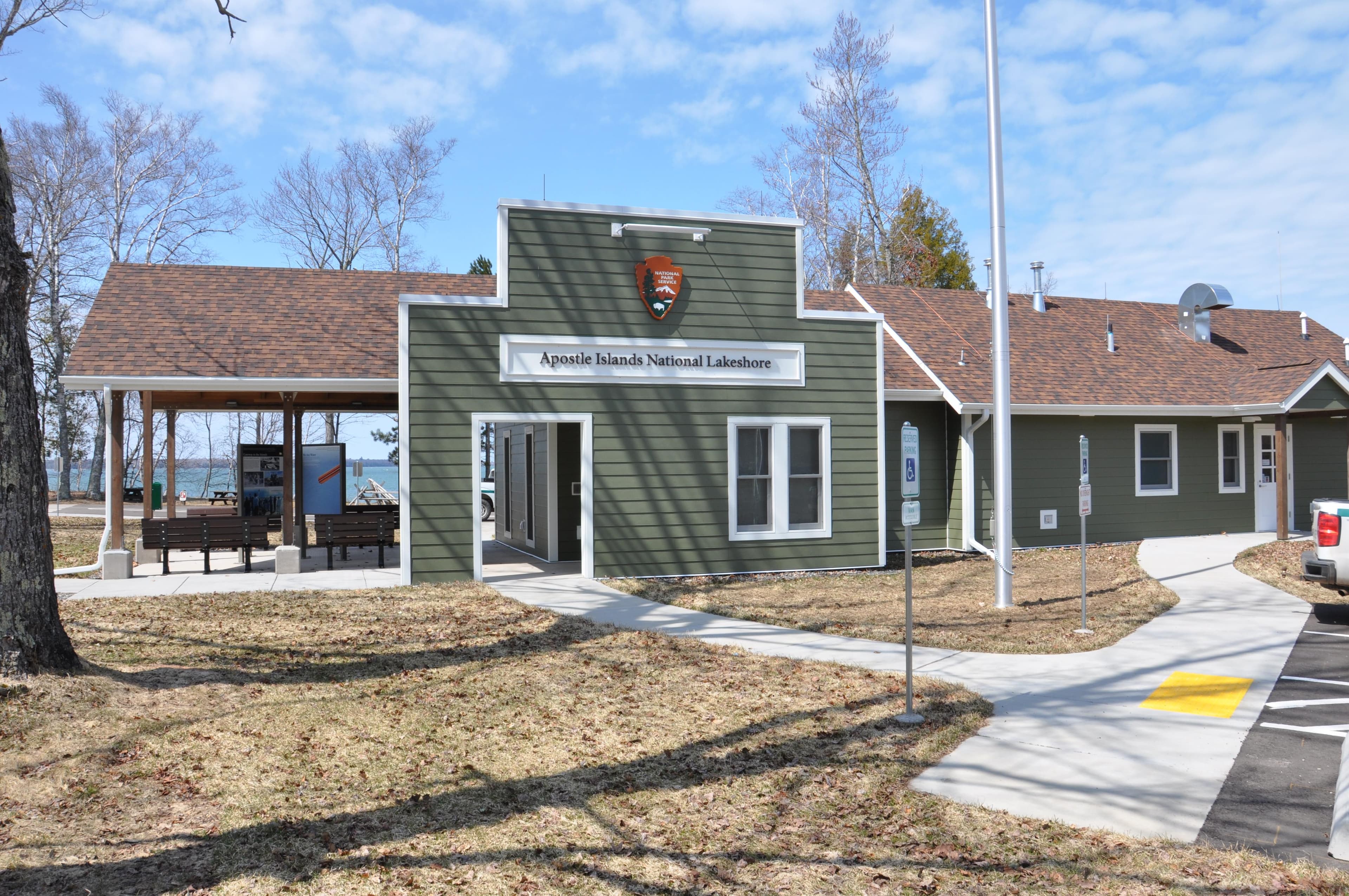 A single story green building with a covered porch on one end.