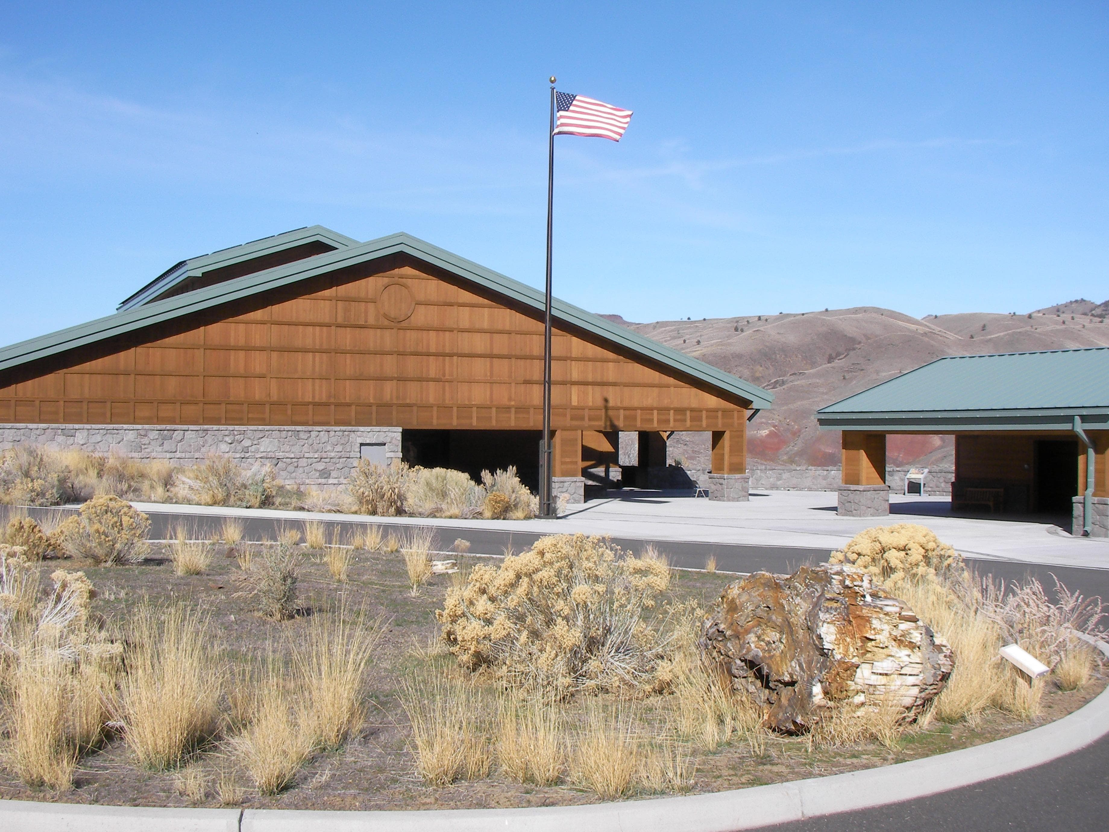 Green roofed building with flag pole.