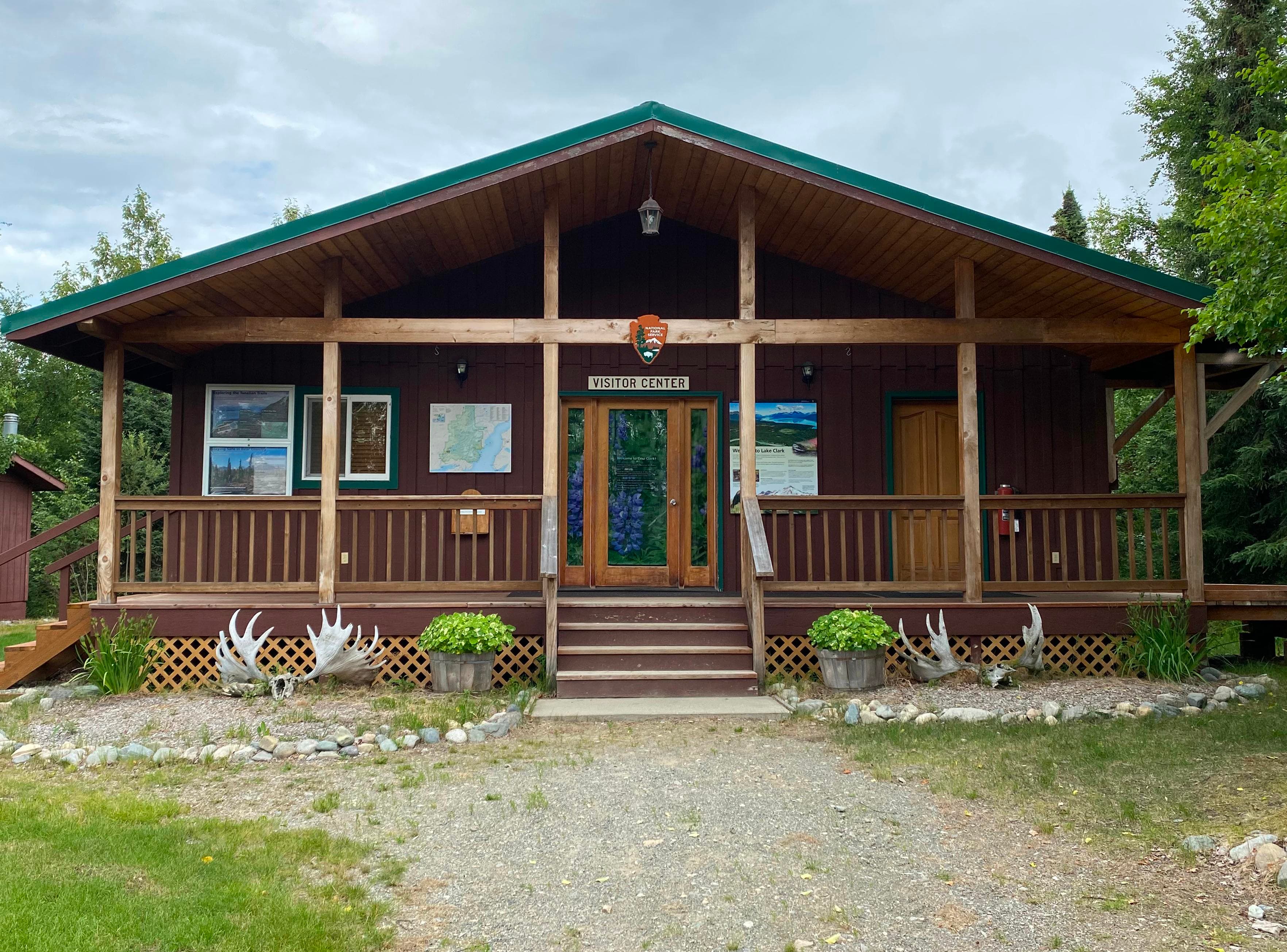 A wooden building with the NPS Arrowhead and outdoor exhibits