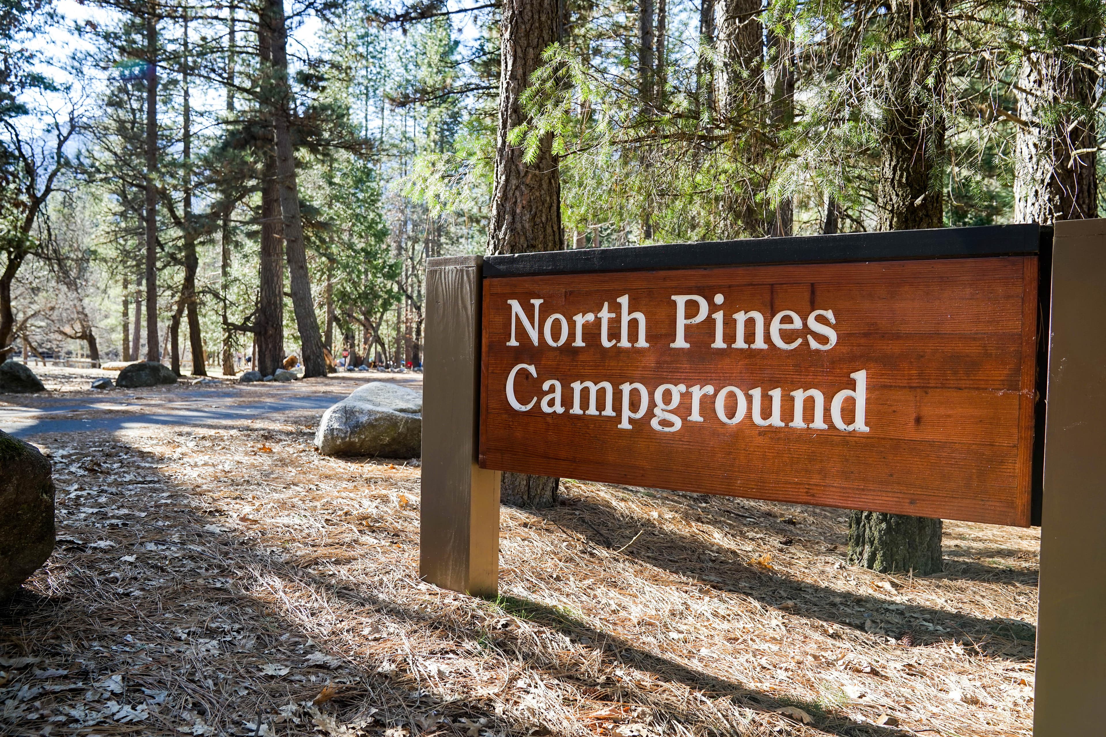 A wood sign at the entrance of a campground reads, North Pines Campground.