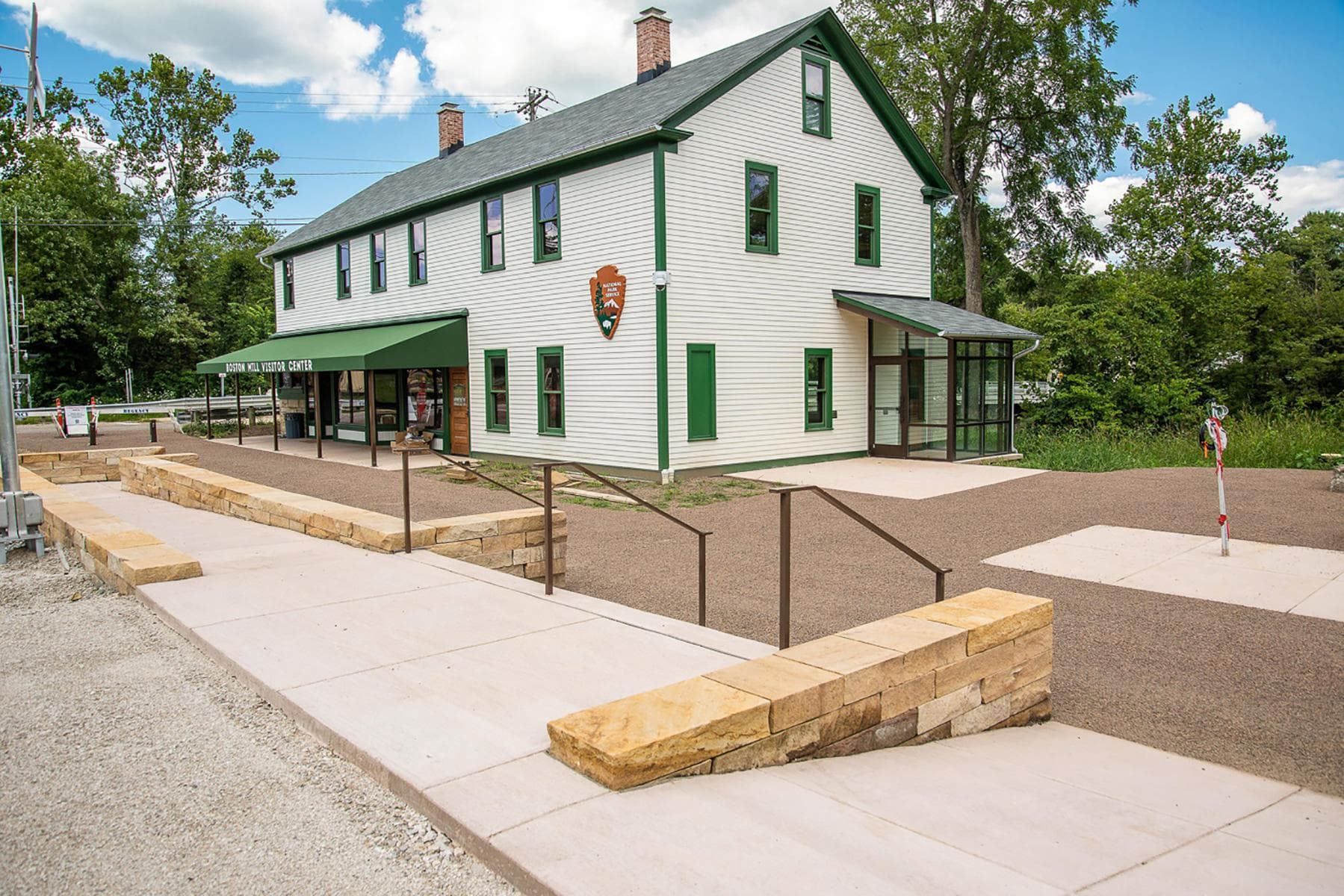 The exterior of Boston Mill Visitor Center, a white building with green trim and awning