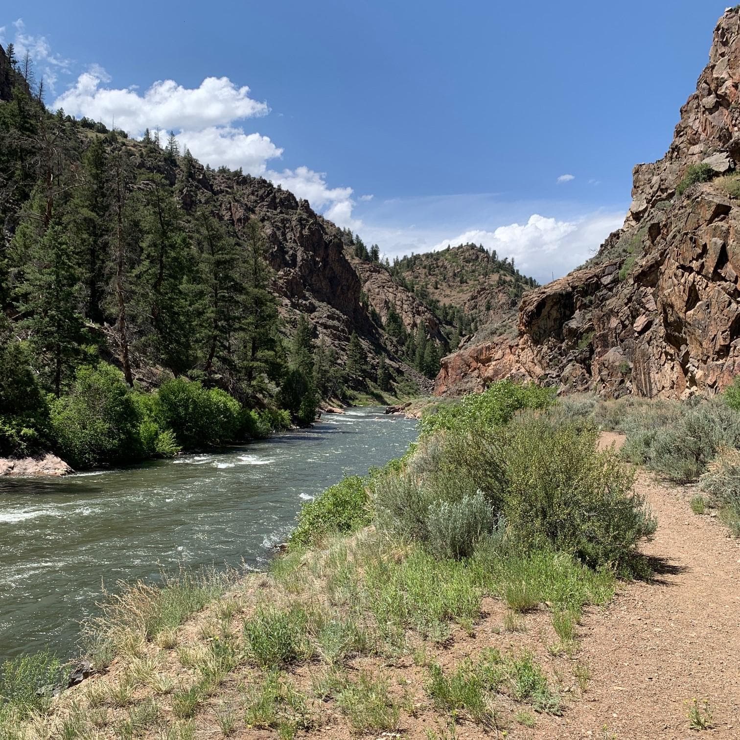 A path along a canyon with a river on the left side