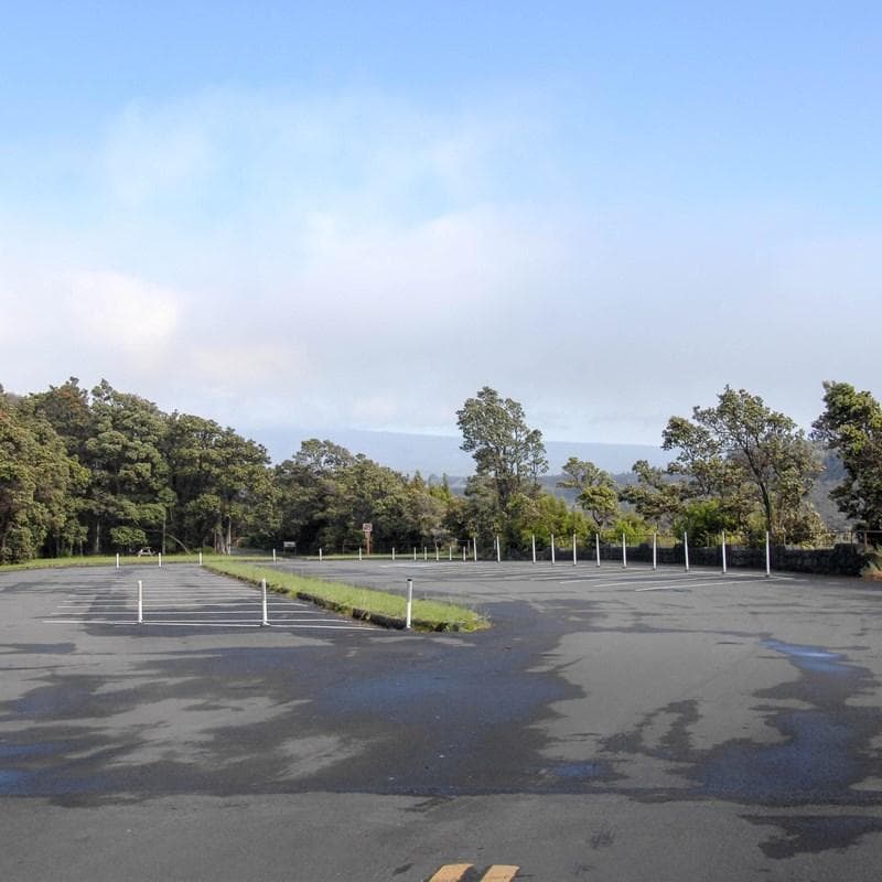 Empty parking lot surrounded by trees.