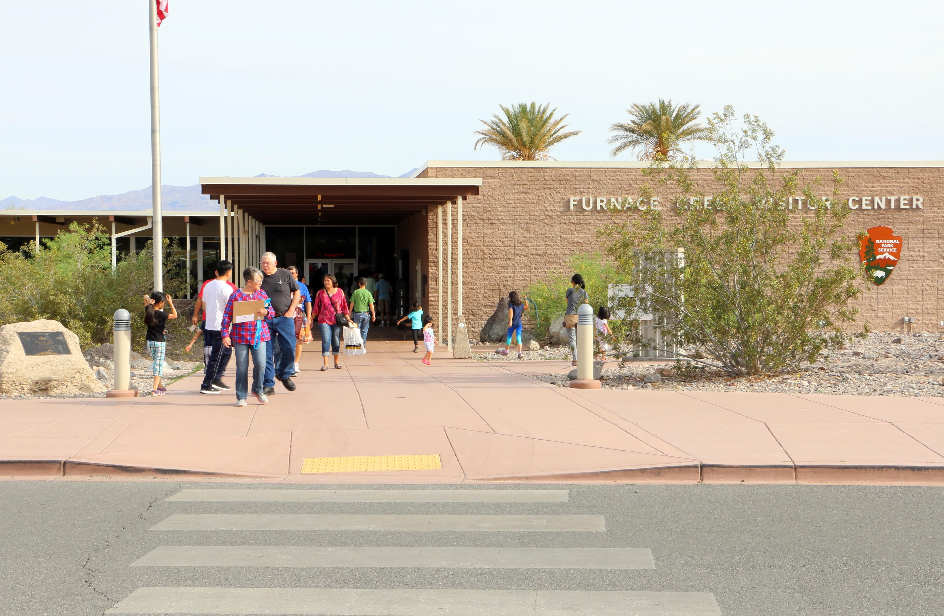 A paved walkway leading to the brick one-story building.